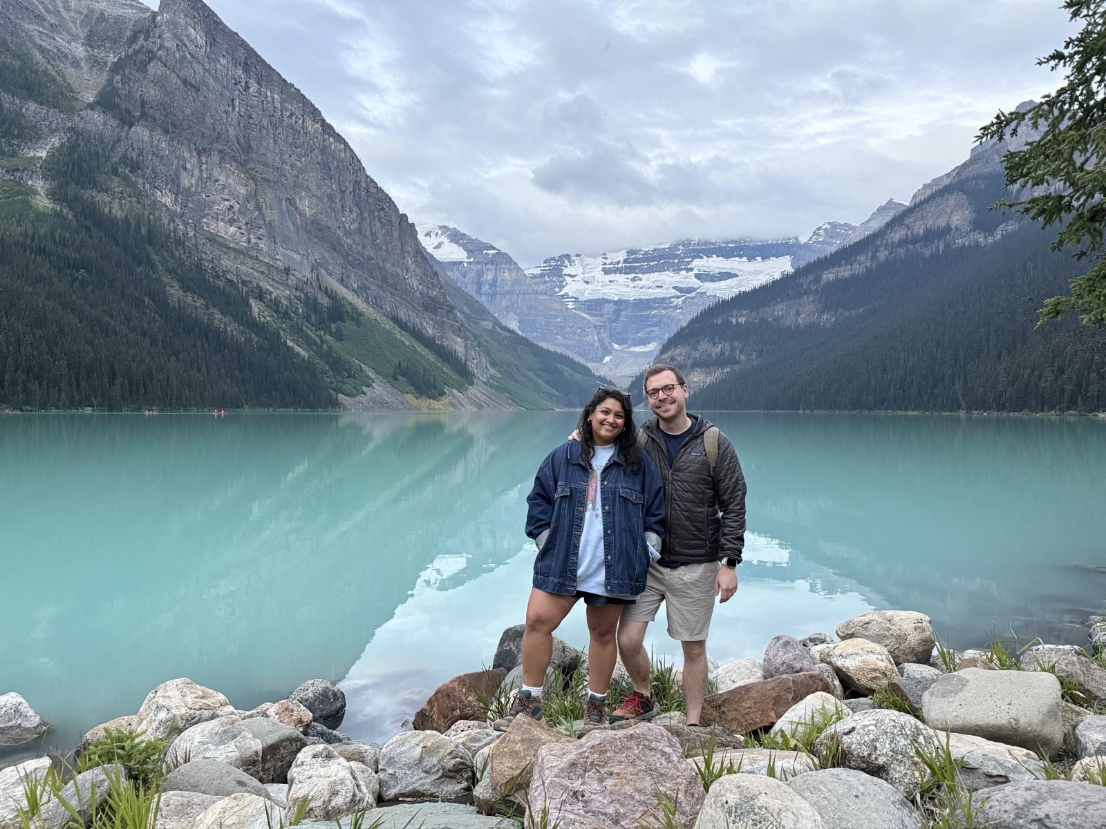 Shaun and Brynelle standing together beside a mountain lake.